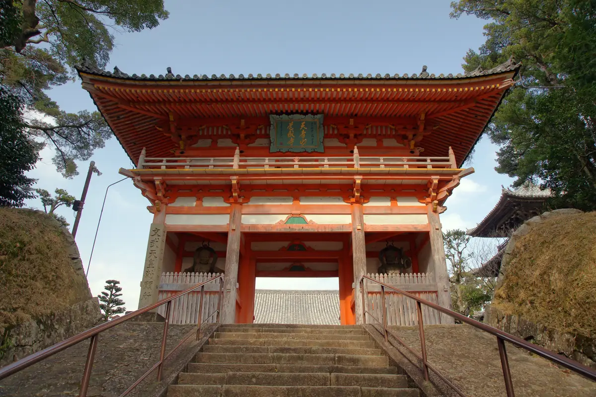 石段の上に建つ道成寺の朱塗りの仁王門