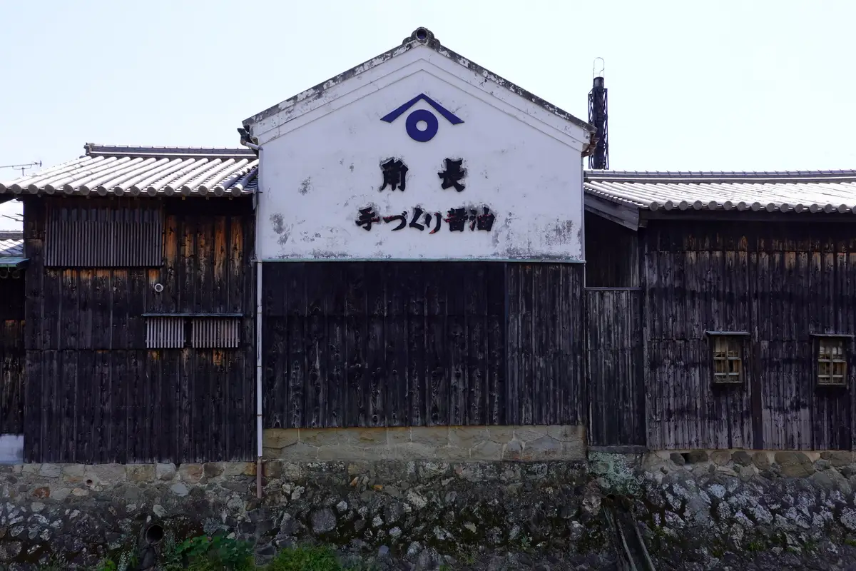 「角長 手づくり醤油」と書かれた角長の白壁の蔵