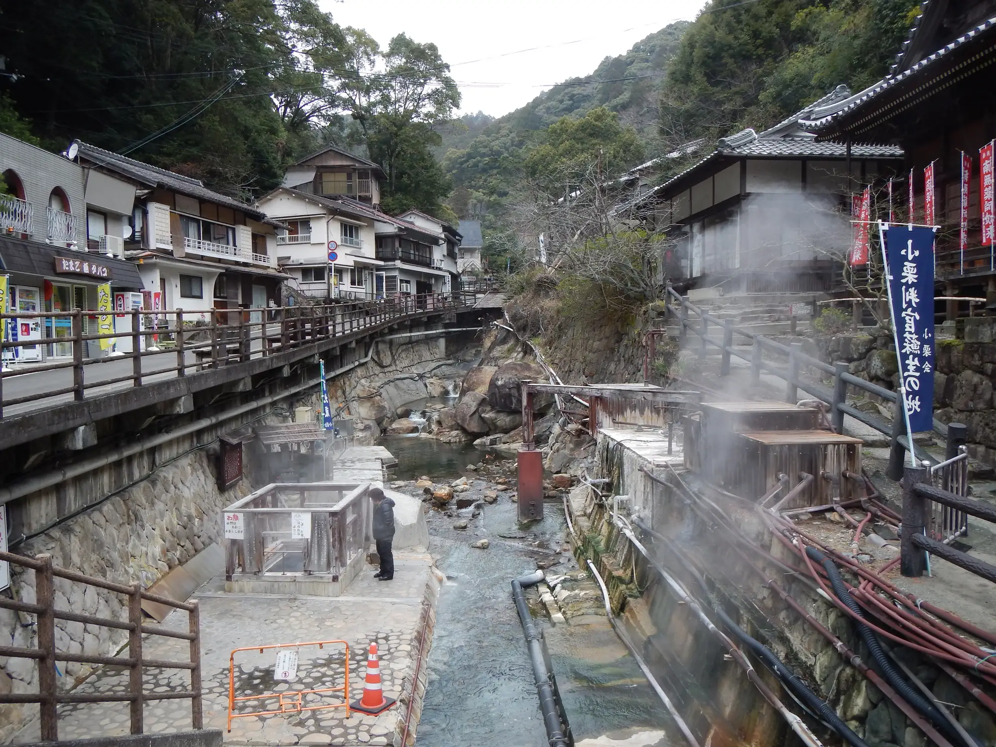 湯けむりが上がる湯の峰温泉の川筋。湯筒や旅館、寺が川沿いに並ぶ